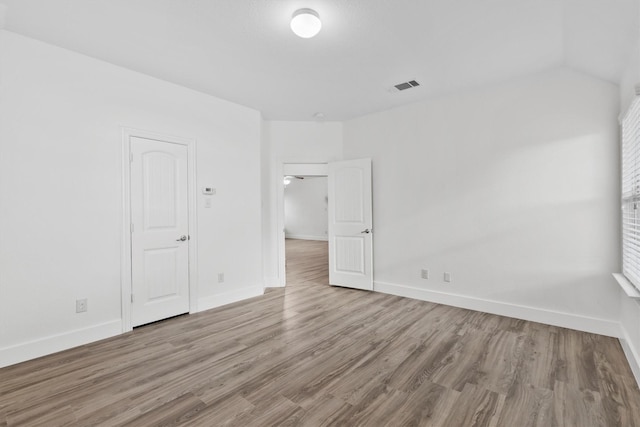 spare room with visible vents, baseboards, and wood finished floors