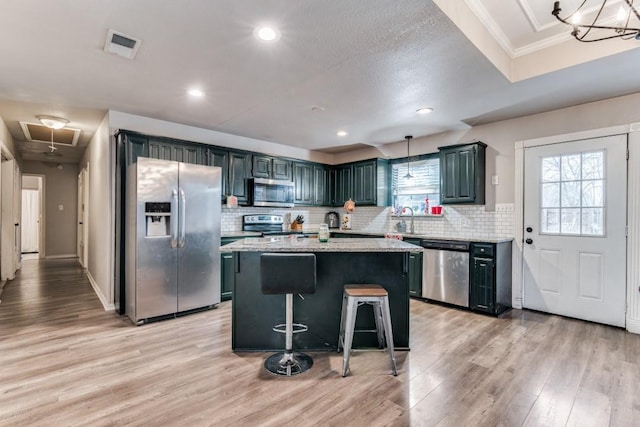 209 E County Line Rd, Royse City, TX 75189 - kitchen with plenty of natural light, a kitchen island, light wood-style flooring, and stainless steel appliances