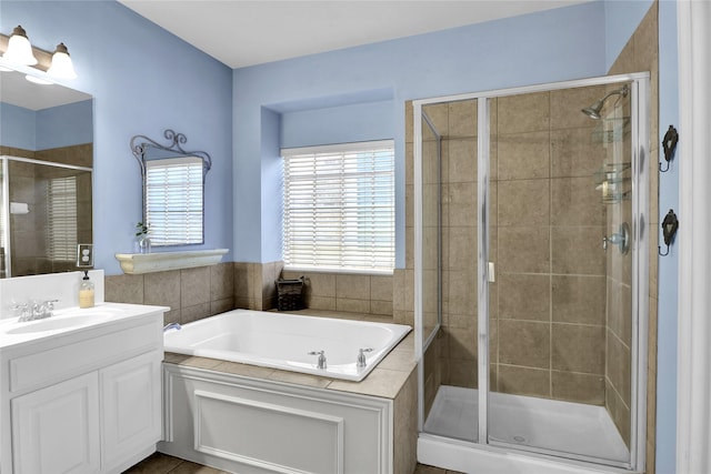 bathroom with vanity, a garden tub, and a stall shower
