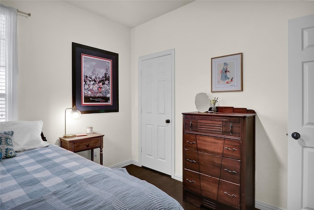 bedroom featuring dark wood finished floors, baseboards, and multiple windows