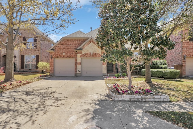 traditional-style home with a garage, concrete driveway, a front yard, brick siding, and roof with shingles