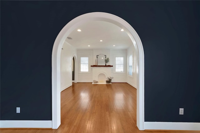 930 N Clinton Ave, Dallas, TX 75208 - unfurnished living room with arched walkways, baseboards, wood finished floors, and recessed lighting