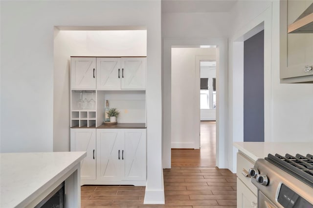 930 N Clinton Ave, Dallas, TX 75208 - kitchen with stainless steel appliances, under cabinet range hood, a sink, a kitchen bar, and baseboards