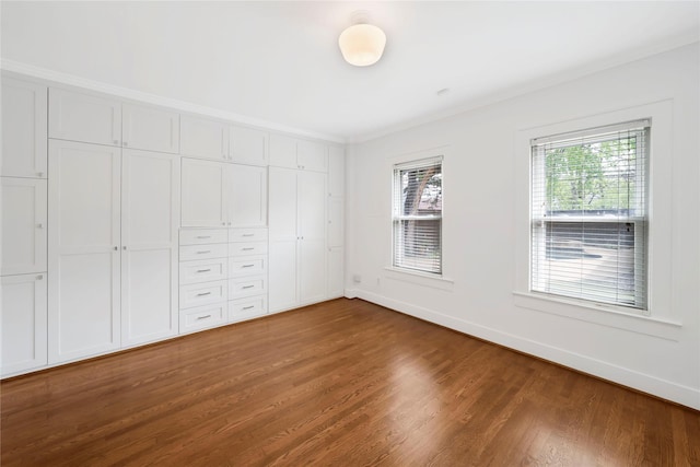 930 N Clinton Ave, Dallas, TX 75208 - unfurnished bedroom featuring wood finished floors, baseboards, ornamental molding, and a closet