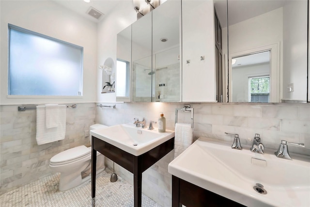 930 N Clinton Ave, Dallas, TX 75208 - full bathroom with tile walls, toilet, tile patterned flooring, two sinks, and an enclosed shower