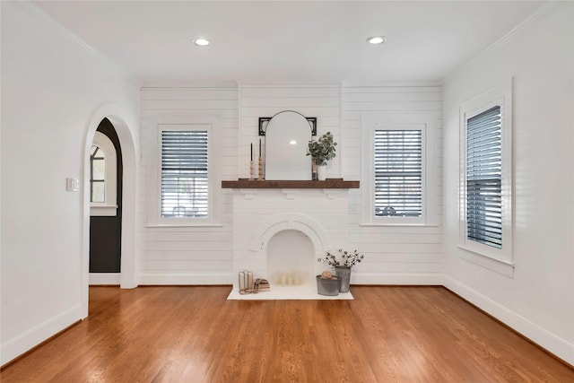 930 N Clinton Ave, Dallas, TX 75208 - unfurnished living room with baseboards, crown molding, wood finished floors, recessed lighting, and arched walkways