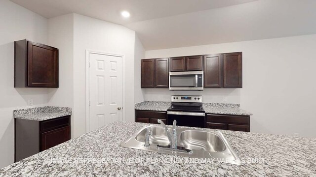 12520 Tarres Ct, Lorena, TX 76655 - kitchen with lofted ceiling, recessed lighting, stainless steel appliances, a sink, and dark brown cabinetry
