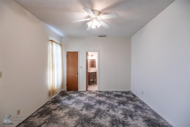 unfurnished bedroom with carpet flooring, a ceiling fan, a textured ceiling, and visible vents