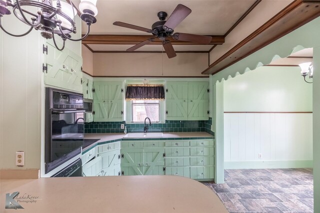 kitchen featuring a sink, dobule oven black, stone finish floor, ceiling fan with notable chandelier, and decorative backsplash