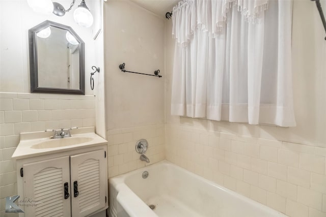 bathroom with a bath, tile walls, and vanity