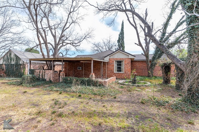 rear view of house with brick siding, a tile roof, and covered porch