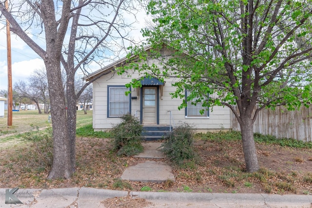 bungalow-style home with fence