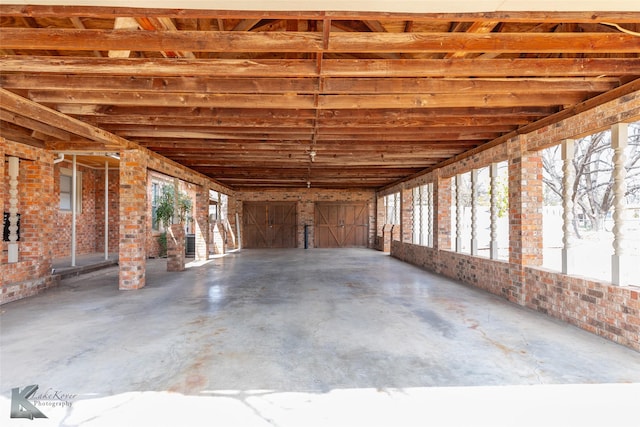 interior space featuring concrete flooring, a wealth of natural light, and brick wall