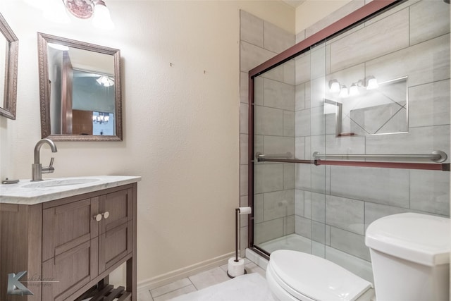 full bath with toilet, vanity, a shower stall, tile patterned flooring, and baseboards
