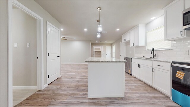 5609 Maceo Ln, Fort Worth, TX 76112 - kitchen featuring appliances with stainless steel finishes, a sink, a kitchen island, white cabinets, and recessed lighting