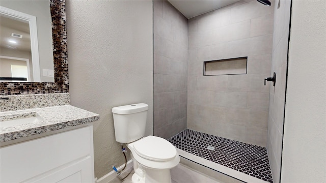 5609 Maceo Ln, Fort Worth, TX 76112 - bathroom with a tile shower, toilet, vanity, and baseboards