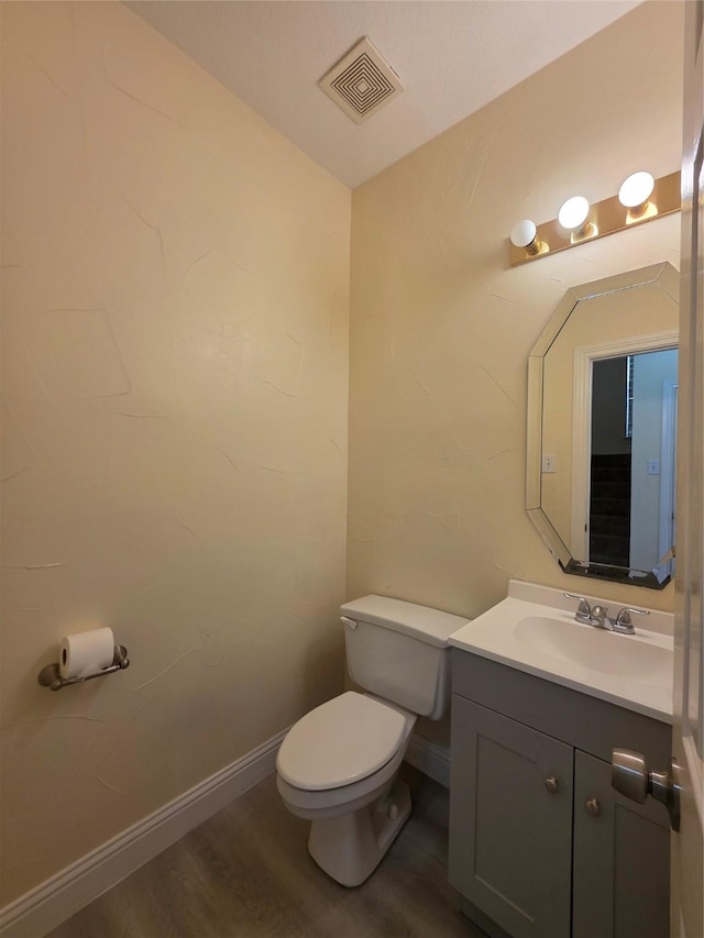 701 Canal St, Irving, TX 75063 - half bath with toilet, vanity, wood finished floors, and baseboards