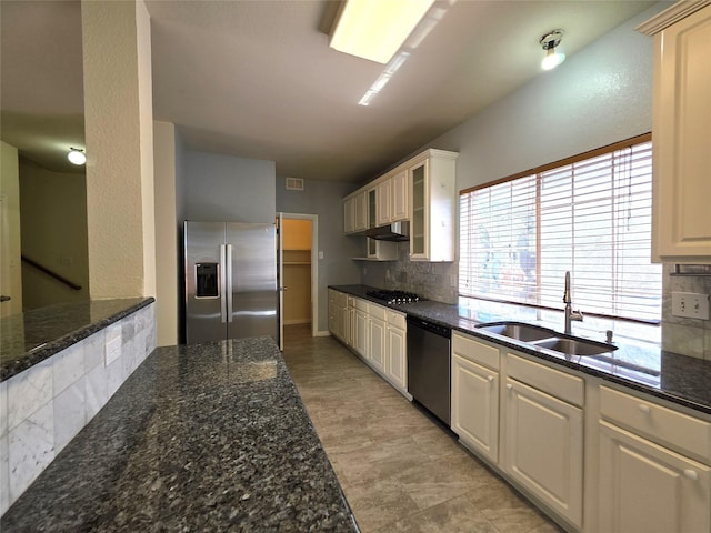 701 Canal St, Irving, TX 75063 - kitchen featuring stainless steel appliances, a sink, under cabinet range hood, decorative backsplash, and vaulted ceiling