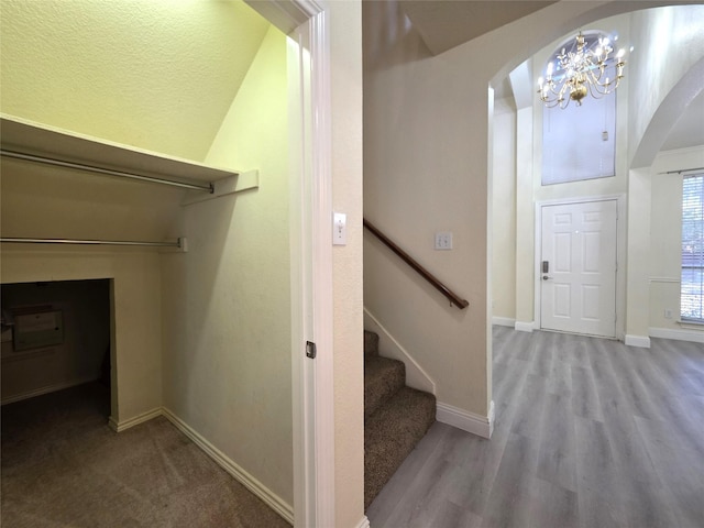 701 Canal St, Irving, TX 75063 - staircase featuring arched walkways, a chandelier, baseboards, and wood finished floors