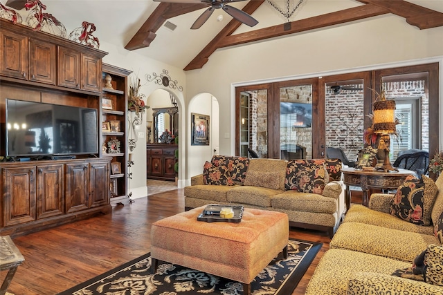 living room with visible vents, beamed ceiling, a ceiling fan, dark wood finished floors, and arched walkways