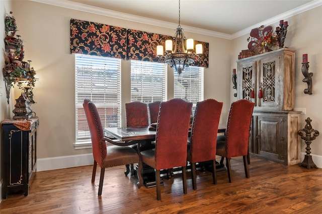 dining room featuring baseboards, ornamental molding, wood finished floors, and a chandelier