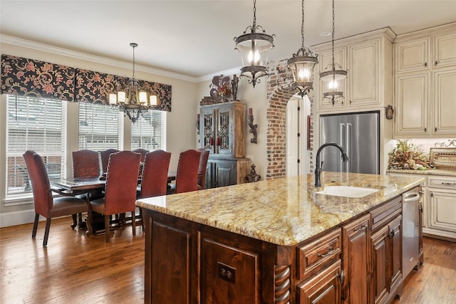 kitchen featuring cream cabinetry, high end fridge, a sink, and wood finished floors