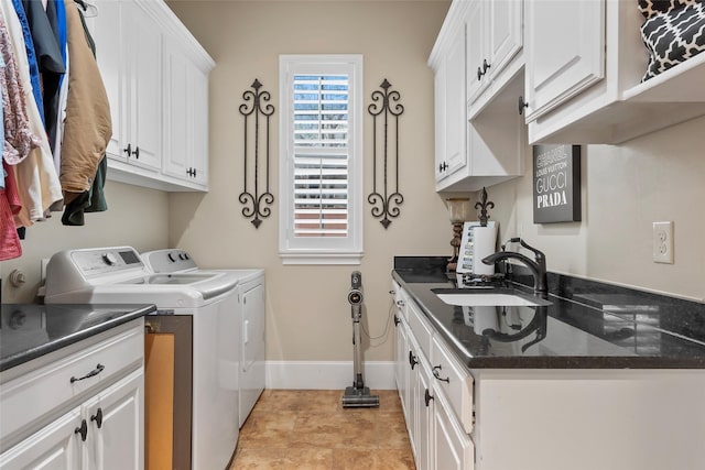 laundry room featuring baseboards, cabinet space, a sink, and separate washer and dryer