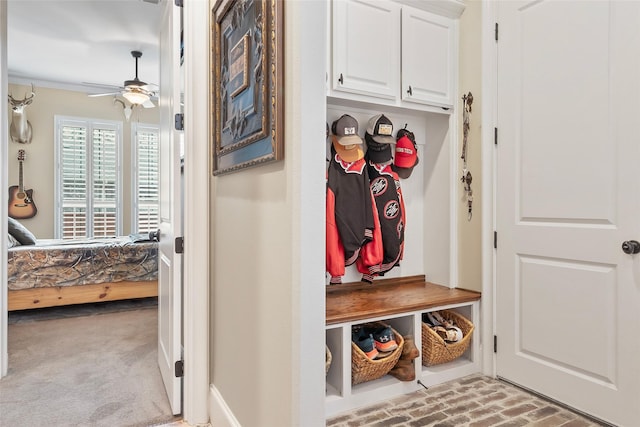mudroom featuring a ceiling fan and brick floor