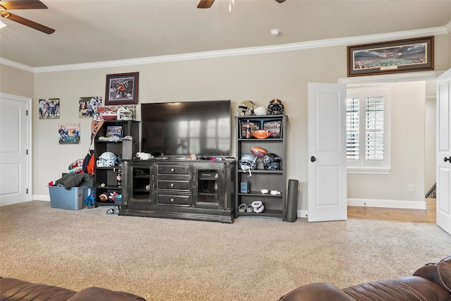 carpeted living room with baseboards, crown molding, and ceiling fan