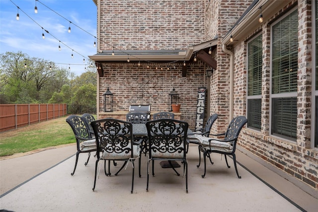 view of patio with a grill, outdoor dining area, and fence