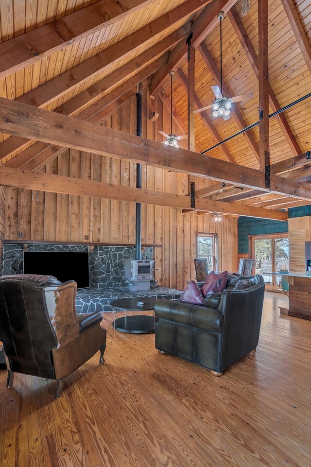 living area with vaulted ceiling with beams, wood finished floors, wood ceiling, and wood walls