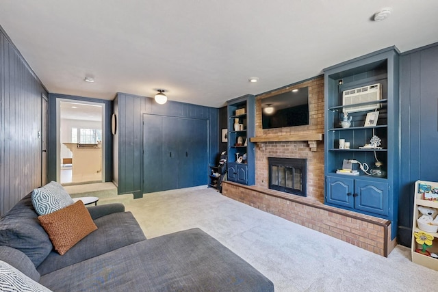 carpeted living room featuring a wall unit AC, wood walls, and a brick fireplace