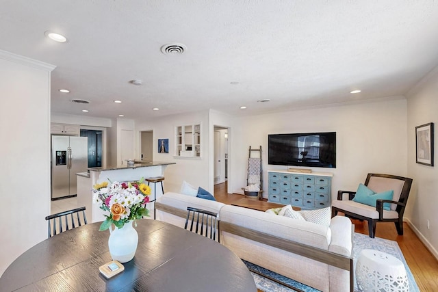 living area featuring recessed lighting, light wood-style floors, visible vents, and baseboards