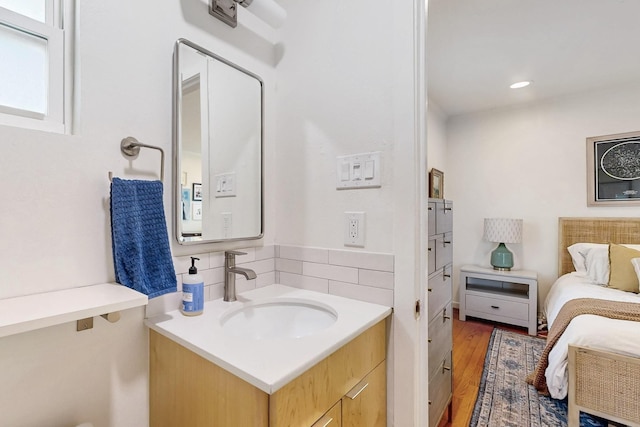 bathroom with decorative backsplash, recessed lighting, vanity, and wood finished floors