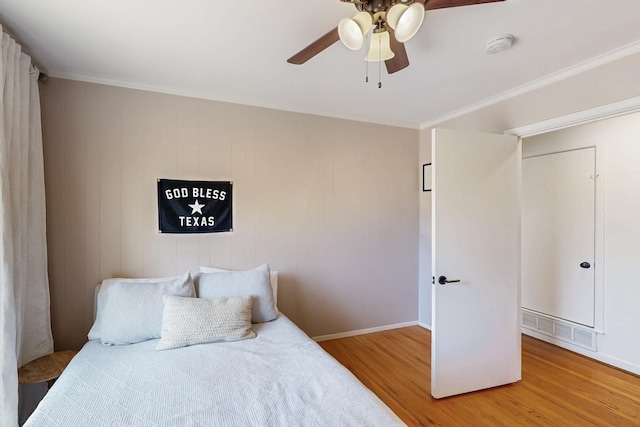 bedroom with visible vents, baseboards, a ceiling fan, and wood finished floors