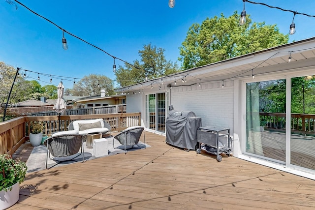wooden deck with a grill and an outdoor hangout area