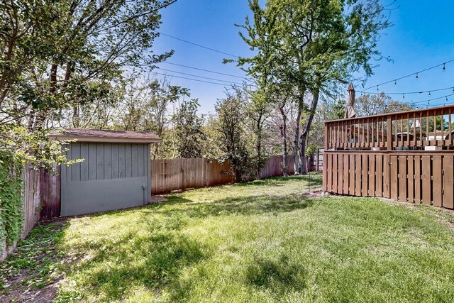 view of yard featuring a storage shed, an outbuilding, and a fenced backyard
