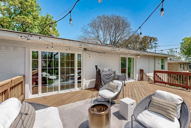 deck featuring a grill and an outdoor fire pit