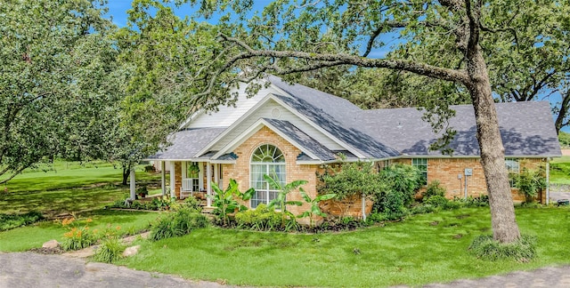 130 Vz County Road 3509, Edgewood, TX 75117 - view of front of house with a front lawn, a shingled roof, a porch, and brick siding