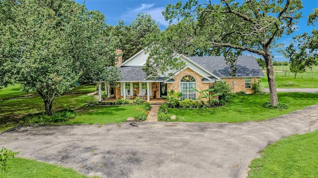 130 Vz County Road 3509, Edgewood, TX 75117 - view of front of house with covered porch, brick siding, roof with shingles, and a front lawn