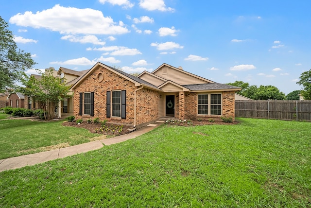 single story home featuring brick siding, a front yard, and fence