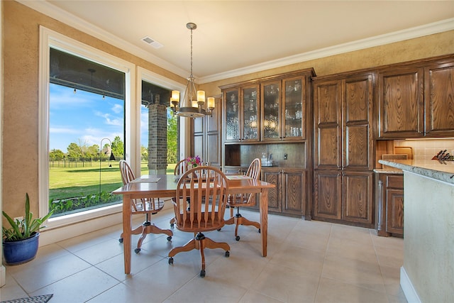 dining space featuring a notable chandelier, visible vents, and ornamental molding