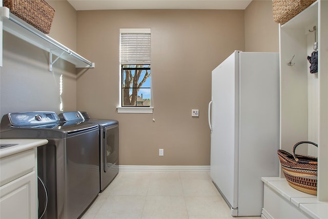 washroom featuring laundry area, baseboards, and washer and clothes dryer
