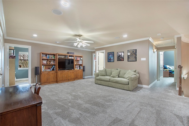 living area featuring crown molding, baseboards, a ceiling fan, and light colored carpet