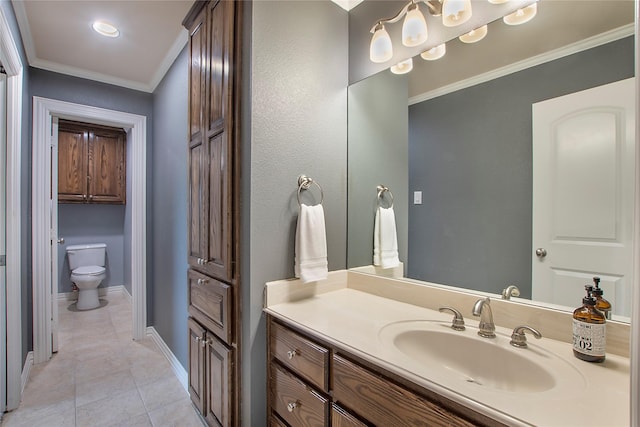 bathroom with baseboards, ornamental molding, toilet, vanity, and tile patterned floors
