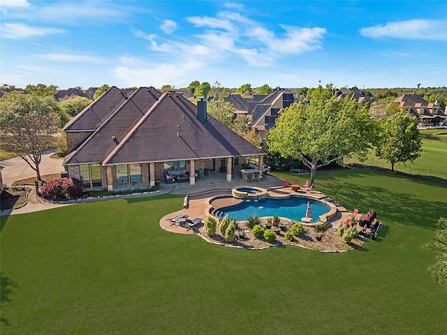 view of swimming pool featuring a yard, a pool with connected hot tub, and a patio