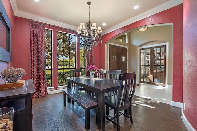 dining area featuring a textured wall, arched walkways, a notable chandelier, and crown molding