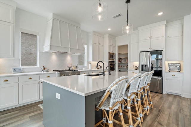 3340 Cabin Crest Pl, Frisco, TX 75033 - kitchen featuring stainless steel appliances, a sink, wall chimney range hood, a kitchen island with sink, and decorative backsplash