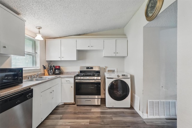 kitchen with visible vents, appliances with stainless steel finishes, dark wood finished floors, white cabinets, and washer / dryer