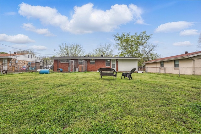 back of property with fence, a lawn, and brick siding